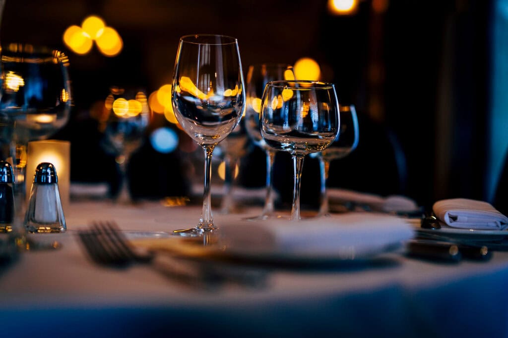 Elegant glassware set for fine dining or celebration with sophisticated ambiance and warm lighting.