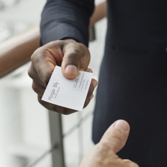 Business professional exchanging contact information with a name badge at a networking event.