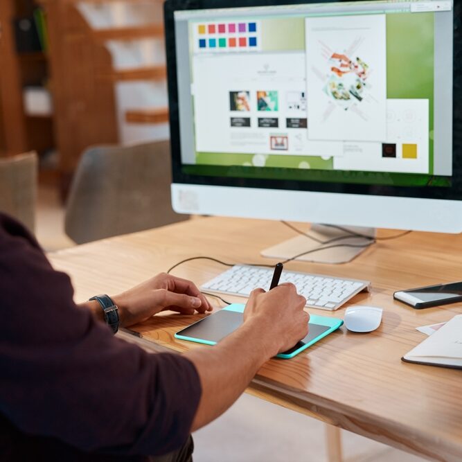 Innovative graphic design work on a desktop computer with a drawing tablet, professional workspace environment.